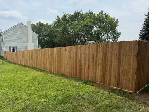Long cedar privacy fence run along a property line