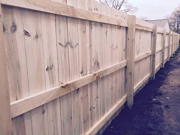 Cedar fence corner with black gate hardware and post caps