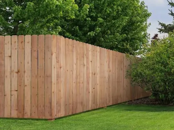 Cedar privacy fence enclosing a residential back lawn
