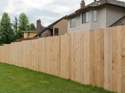 Flat-top cedar fence line between neighboring homes
